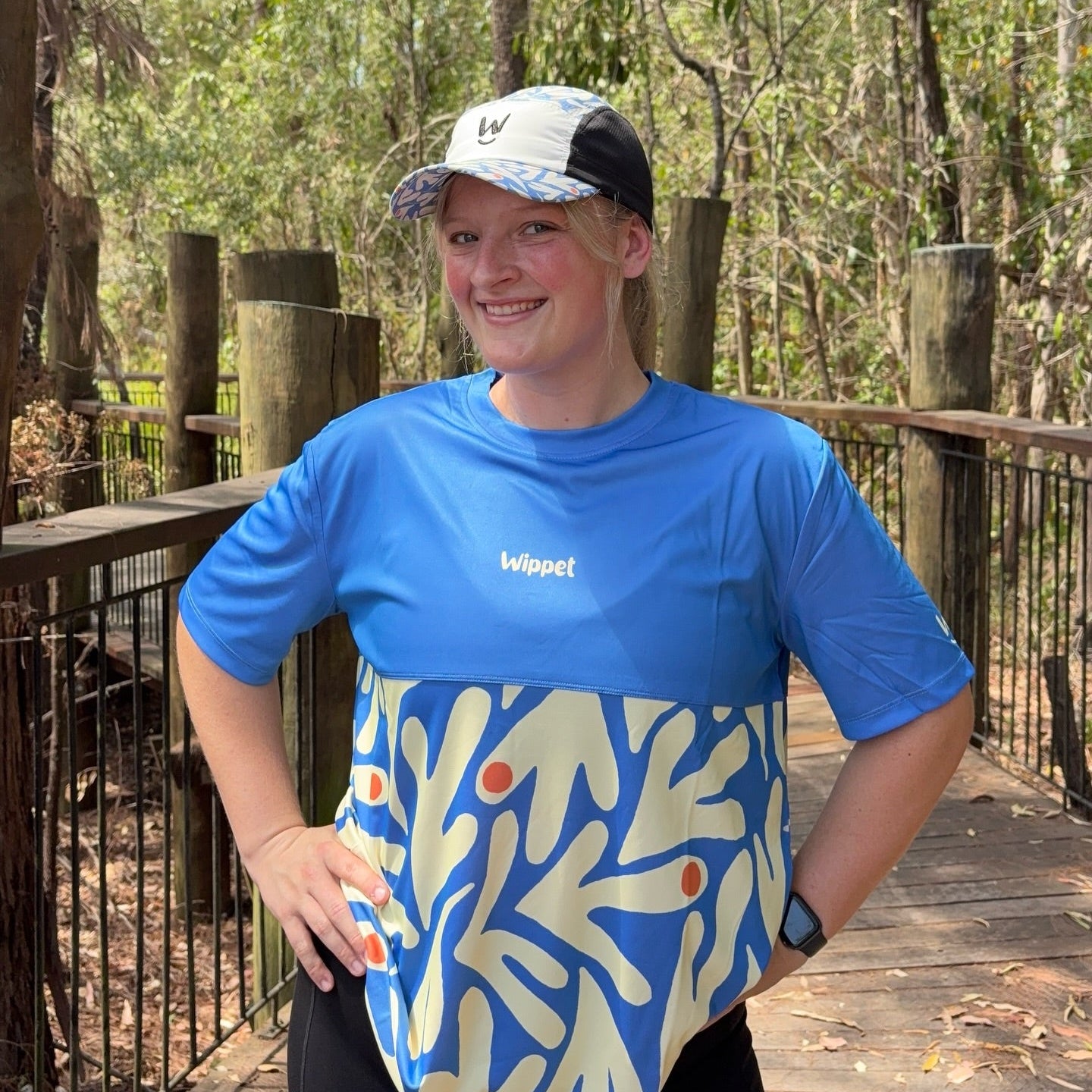 Woman wearing Wippet Coconut Cool Everyday Running Shirt with breathable, sweat wicking fabric smiling.