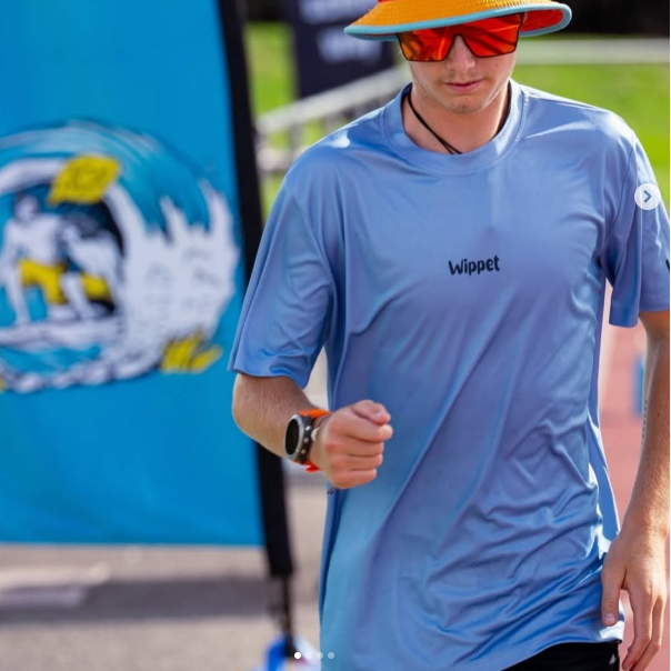 Person happily wearing a the Atomizer 'Wippet' Everyday Running shirt while running an ultra marathon