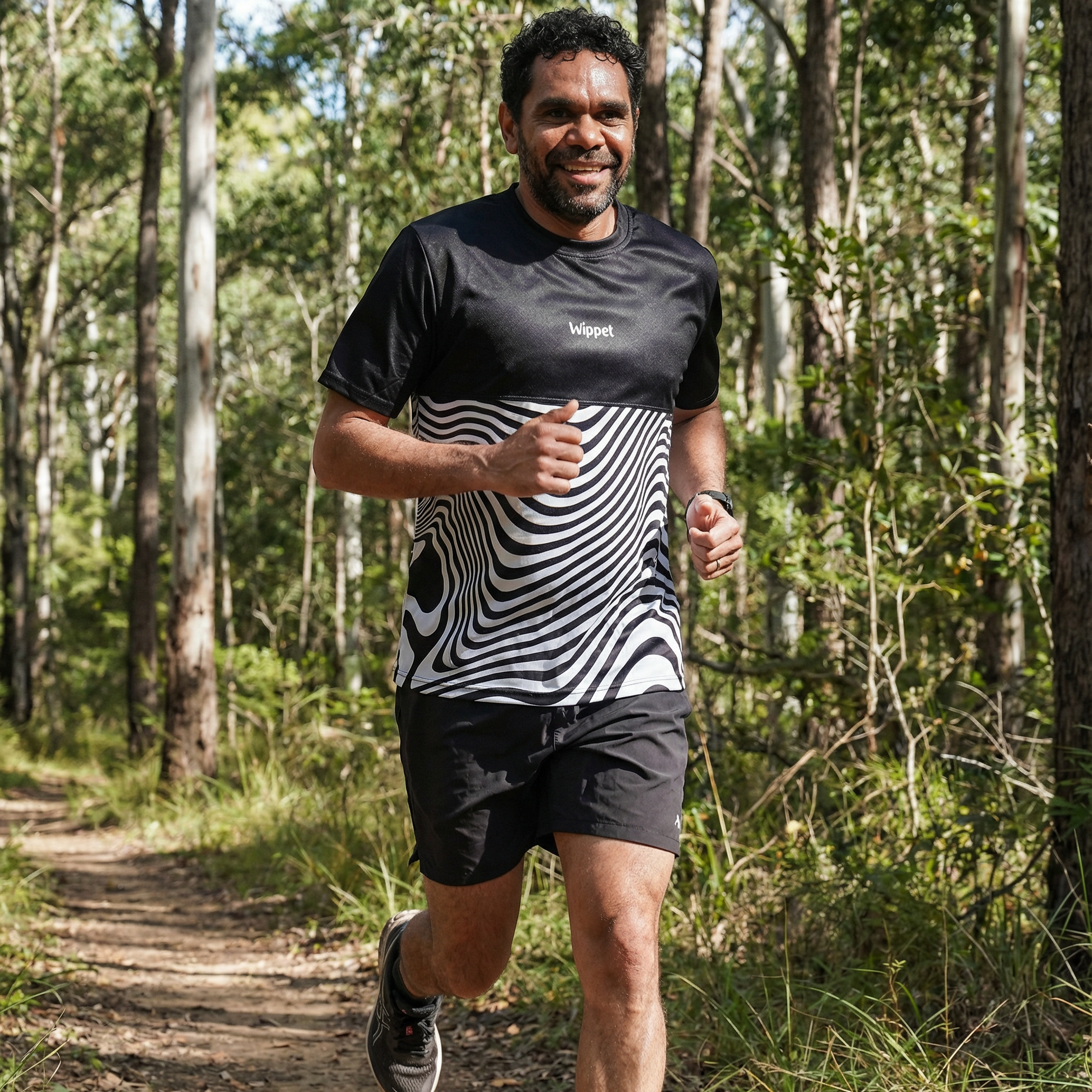 Man running on a trail in a forest wearing a Wippet Everyday Running Shirt that is sun protection, breathable, light and sweat wicking.