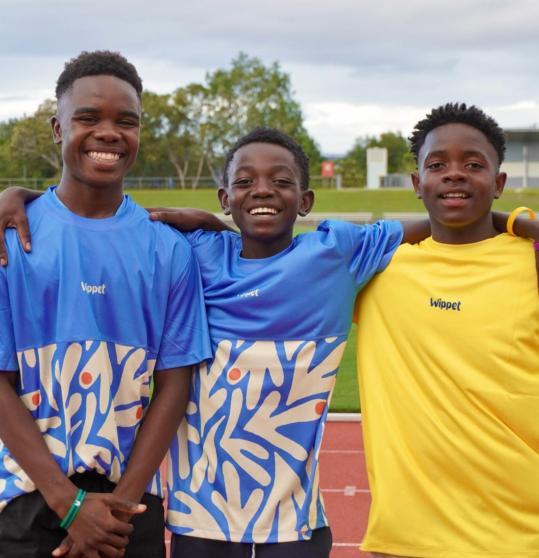 Runners in Wippet lightweight technical running tees with UPF50+ sun protection and fun original prints training on a running track