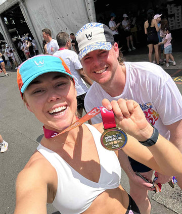 Runners wearing Wippet running caps celebrating with race medals at Bridge to Brisbane Marathon